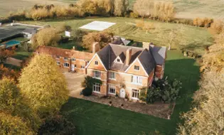 This serene property is home to Khiron Clinics, a leading center for trauma treatment, nestled in a pastoral landscape that extends into the distance under a clear sky.