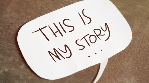 A speech bubble cutout on a brown surface with the handwritten text "THIS IS MY STORY..." inside, reflecting the personal journeys often shared at a trauma clinic.