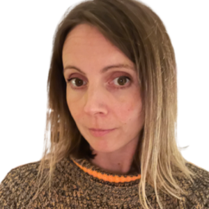 A woman with shoulder-length, light brown hair is looking at the camera, wearing a cozy brown and orange sweater. Behind her, a plain white background provides a serene setting—much like the calming spaces found at Khiron Clinics.