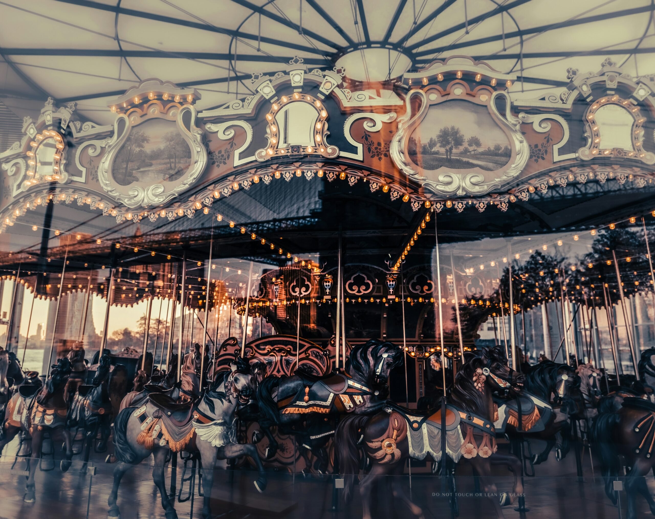 A vintage carousel with ornate details and painted horses, illuminated by warm string lights, sits under a canopy. The dreamy reflections evoke the body's response to stress, mirroring layers of emotion beneath the surface.