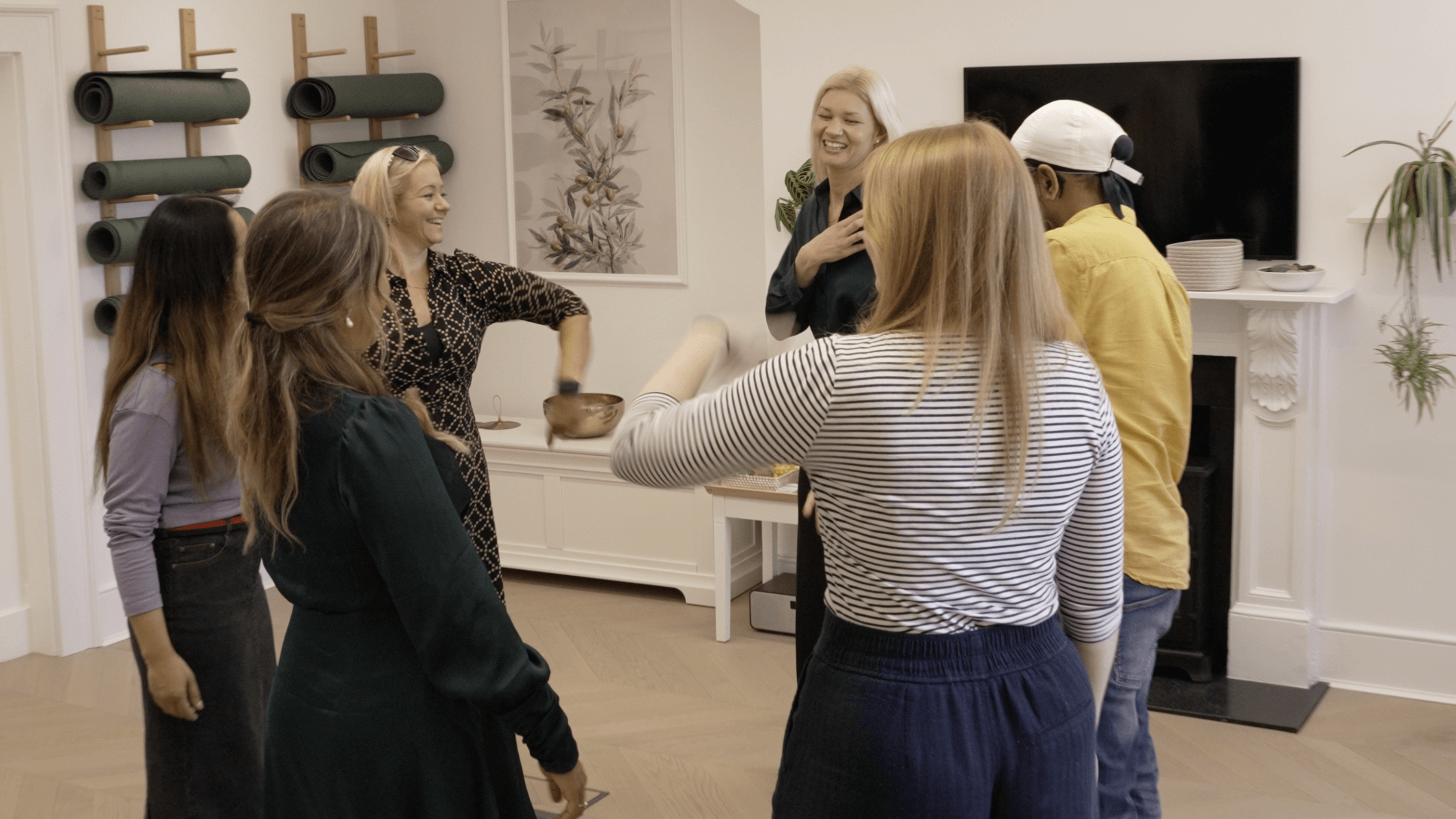 Six people stand in a circle doing a somatic movement workshop - image for trauma therapist interview